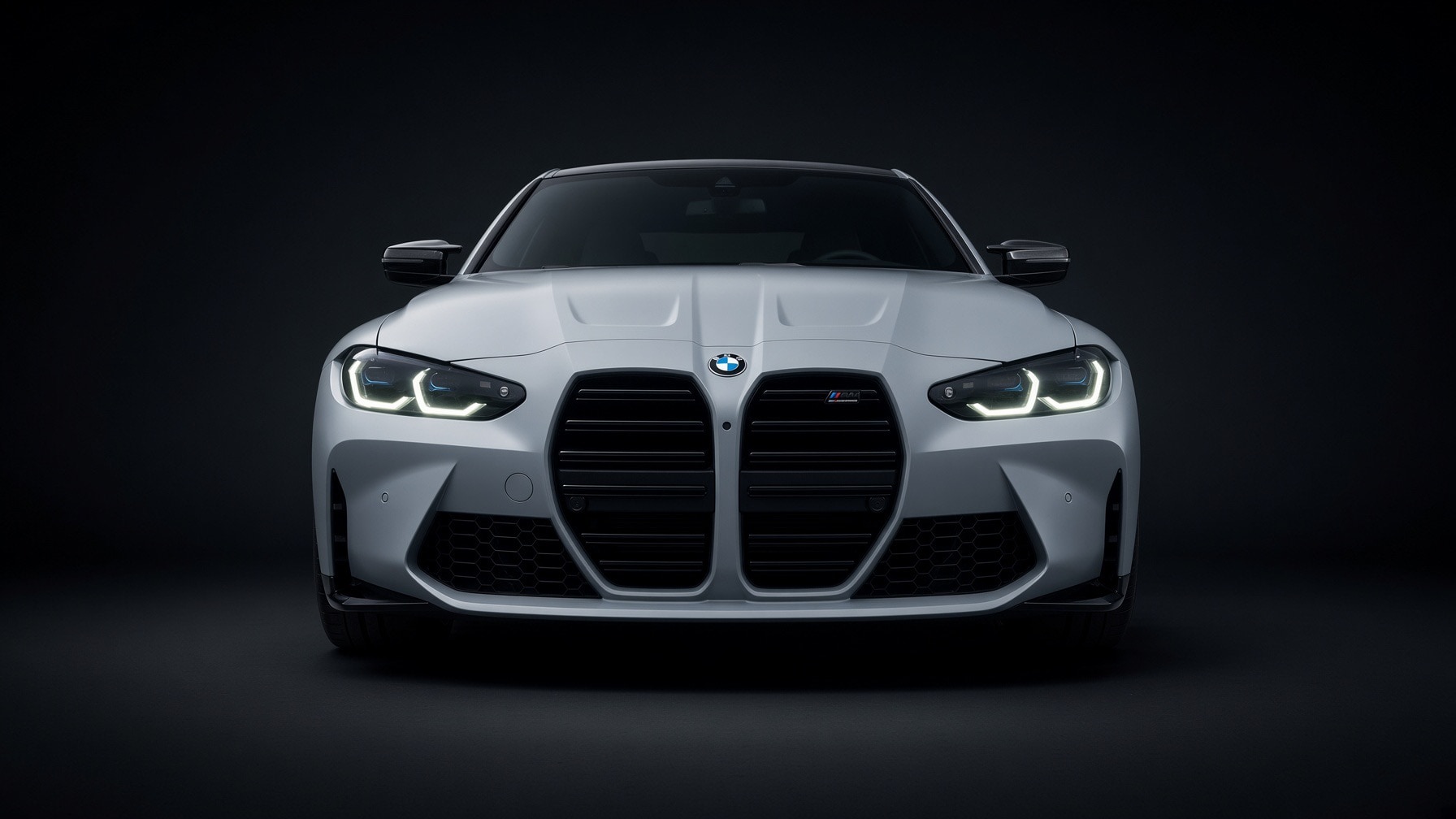 Front view of a BMW M3 in a dark studio setting
